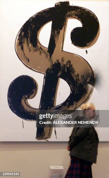 Museum staffer passes by Andy Warhol's " Dollar Sign" created in 1981, during a Warhol exhibition in Moscow's Pushkin Arts Museum, 28 May 2001,...