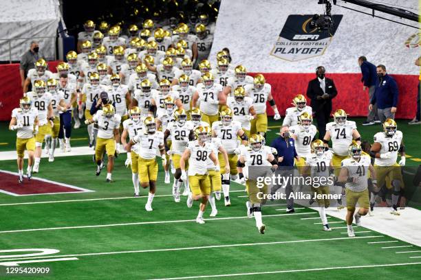 The Notre Dame Fighting Irish run on the field during player introductions before the College Football Playoff Semifinal at the Rose Bowl football...