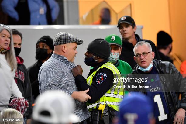 An Arlington police officer tries to control a fan during the College Football Playoff Semifinal at the Rose Bowl football game between the Alabama...