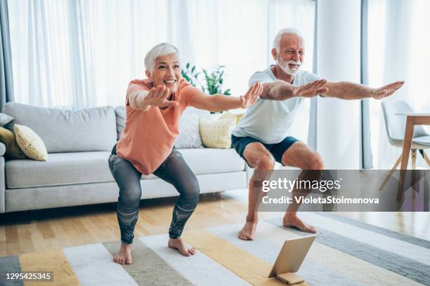 couple exercising together at home. - agachar se imagens e fotografias de stock