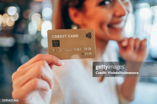 vrouw die een creditcard houdt. - credit stockfoto's en -beelden
