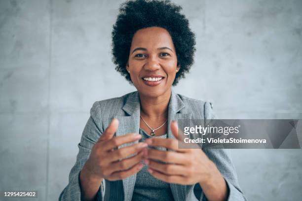 businesswoman talking during video call in the office. - speech stock pictures, royalty-free photos & images