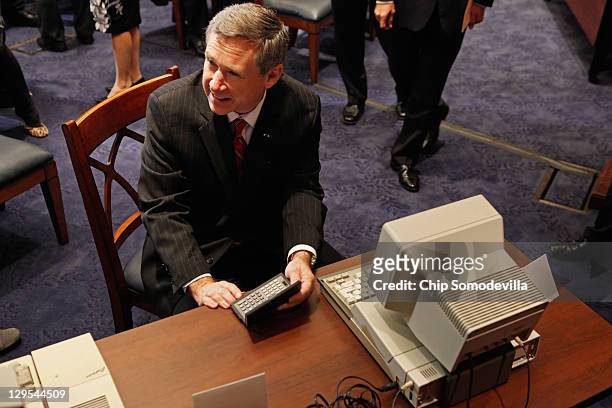 Sen. Mark Kirk looks at at Tandy hand-held PC-5 and a IBM PC Convertable before a news conference about the 25th anniversary of the Electronic...