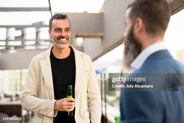 medio volwassen zakenman die een onderbreking heeft die bier drinkt - man sipping beer smiling stockfoto's en -beelden