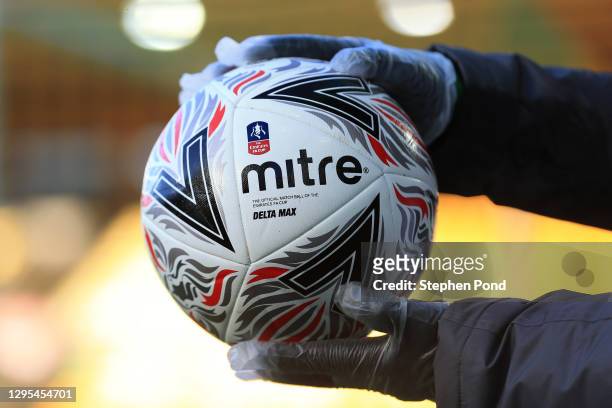 Member of ground staff is seen wearing a pair of gloves as a COVID-19 precaution, as they hold a Mitre Pro Delta FA Cup Match Ball prior to the FA...