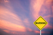 Yellow color transportation sign with word warning on violet cloud sky background