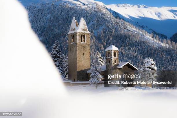 san gian church on snow capped mountains, celerina, switzerland - korktanne stock-fotos und bilder