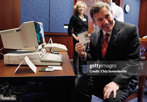 Sen. Mark Kirk pulls a 3.5-inch floppy disc from a IBM PC Convertable before a news conference about the 25th anniversary of the Electronic...