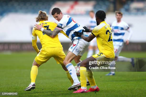 Lyndon Dykes of Queens Park Rangers is challenged by Tim Ream of Fulham and Josh Onomah of Fulham during the FA Cup Third Round match between Queens...