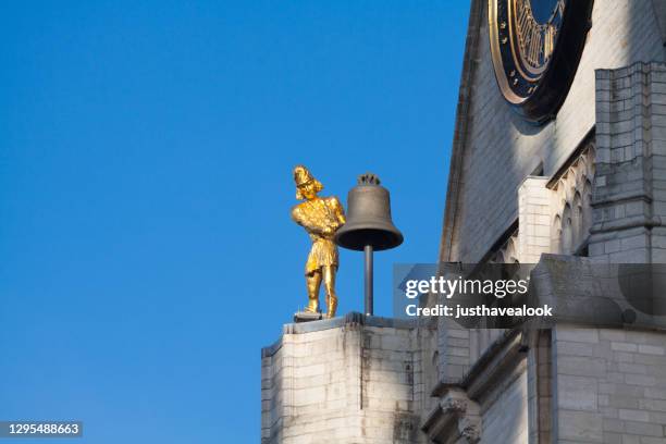 golden bell ringer statue of church st peter in leuven - bell ringer stock pictures, royalty-free photos & images
