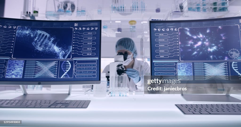 Weibliche Untersuchung von DNA-Proben. Computerbildschirme mit DNA-Sequenzen