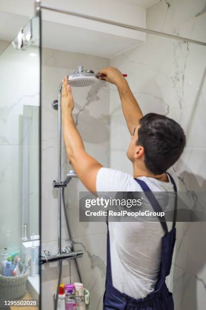 replacing the plumbing in the bathroom mounted hand shower holder with height adjustable a shower head. - shower tap stock pictures, royalty-free photos & images