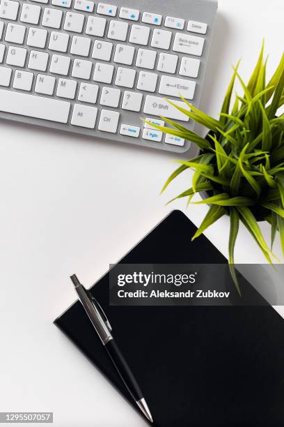 notepad with pen on wooden office desk or white background. next to the laptop keyboard and a flower. top view with space to copy. the concept of business, distance work and education. - writing copy stock pictures, royalty-free photos & images