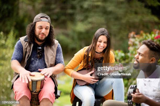 smiling group of diverse friends playing musical instruments together outdoors - bongo drum stock pictures, royalty-free photos & images