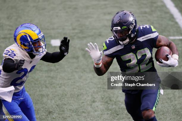 Running back Chris Carson of the Seattle Seahawks carries the football against cornerback Troy Hill of the Los Angeles Rams during the first quarter...