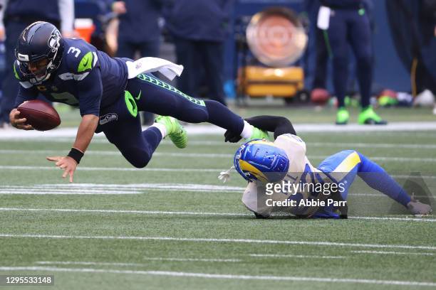Quarterback Russell Wilson of the Seattle Seahawks is tackled by cornerback Troy Hill of the Los Angeles Rams during the second quarter of the NFC...