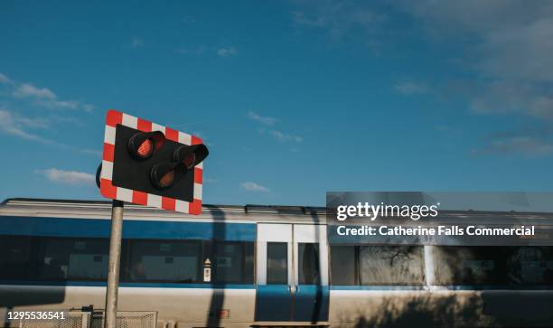 electronic train speeding past a level crossing - lokführer stock-fotos und bilder