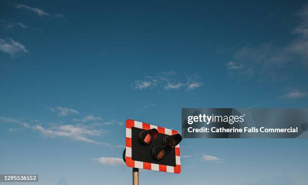 level crossing flashing lights against a blue sky - train crossing stock pictures, royalty-free photos & images