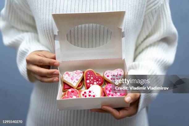 woman holding box with valentine's cookies - candy love stock pictures, royalty-free photos & images
