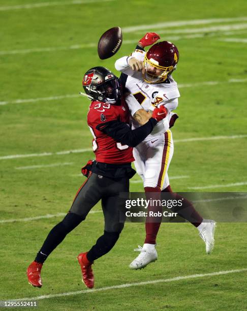 Quarterback Taylor Heinicke of the Washington Football Team releases the ball just as he is hit by free safety Jordan Whitehead of the Tampa Bay...