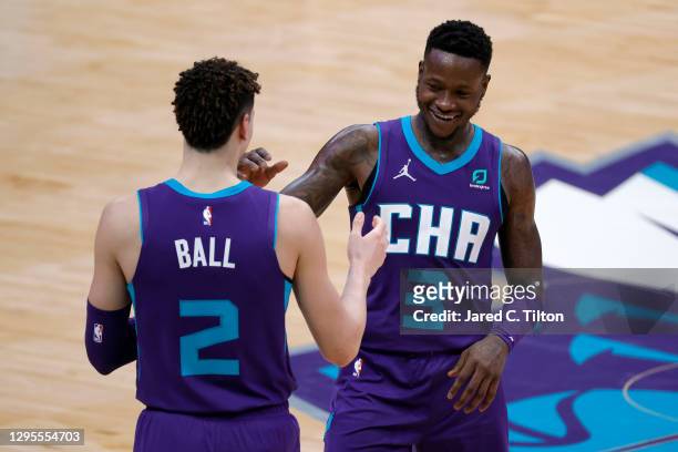 Terry Rozier of the Charlotte Hornets celebrates with teammate LaMelo Ball following their victory over the Atlanta Hawks at Spectrum Center on...