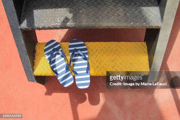flip-flops on yellow steps - metallic shoe 個照片及圖片檔