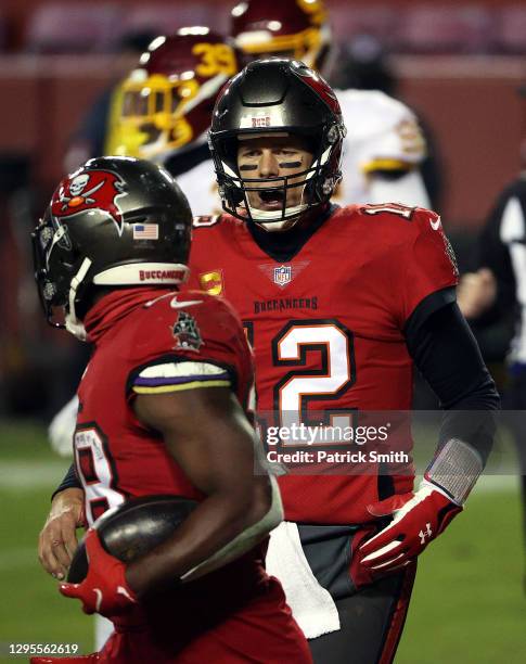 Quarterback Tom Brady of the Tampa Bay Buccaneers congratulates running back Leonard Fournette after a touchdown during the 4th quarter of the game...