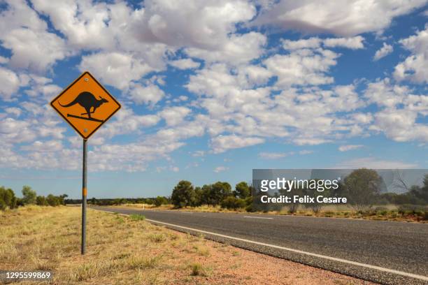 a skiing kangaroo road sign on the stuart highway, australia - outback western australia stock pictures, royalty-free photos & images