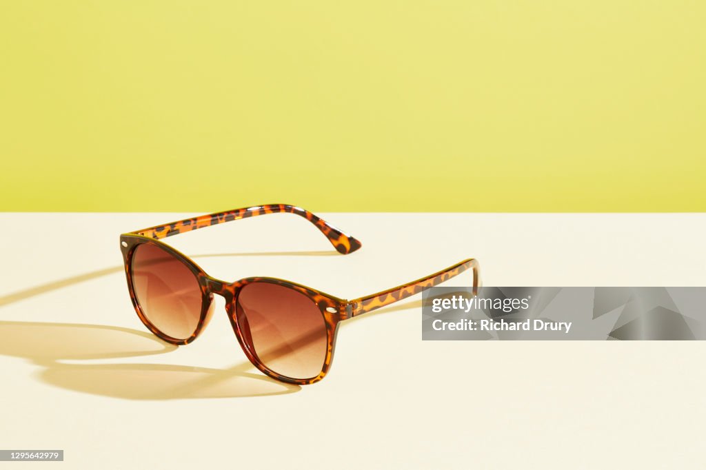 A pair of sunglasses against a yellow background