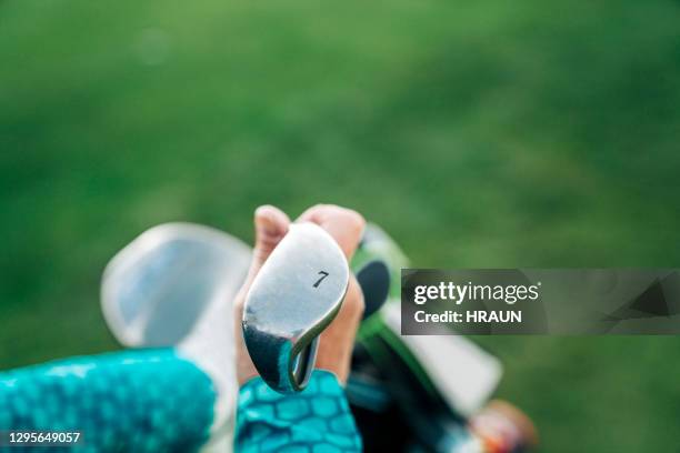 hand of female golfer holding club with number 7 - number 7 stock pictures, royalty-free photos & images