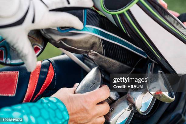 hands of female golfer removing club from bag - golf bag stock pictures, royalty-free photos & images