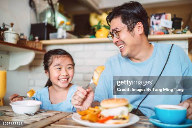 young handsome dad enjoying meal with her lovely daughter in restaurant - breakfast fathers imagens e fotografias de stock