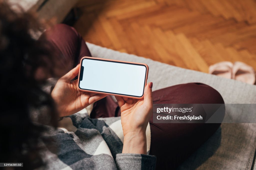 Anonymous Woman Using her Mobile Phone at Home (Blank Screen, Copy Space)