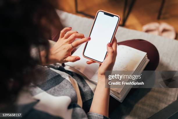 mujer anónima usando su teléfono móvil en casa (pantalla en blanco, copiar espacio) - teléfono inteligente fotografías e imágenes de stock