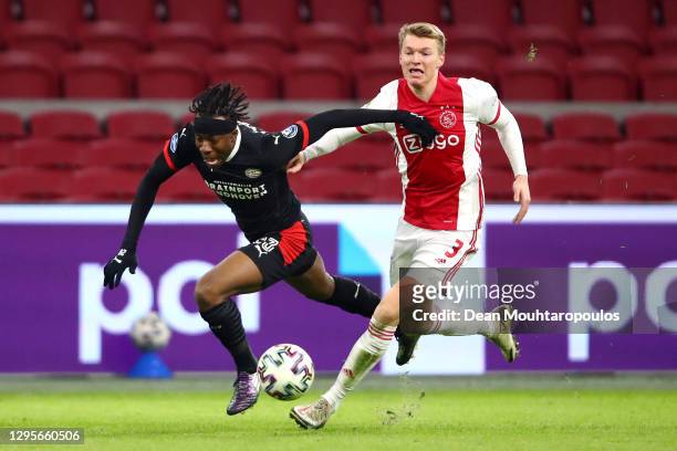 Perr Schuurs of Ajax tackles Noni Madueke of PSV during the Dutch Eredivisie match between Ajax and PSV Eindhoven at Johan Cruijff Arena on January...
