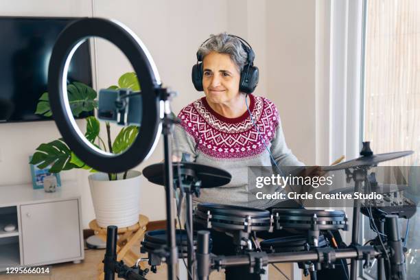 senior youtuber making another video and playing electronic drum kit at home - vlogging stock pictures, royalty-free photos & images