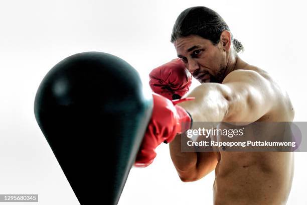 boxer with red boxing gloves punching boxing ball - muay thai stock pictures, royalty-free photos & images