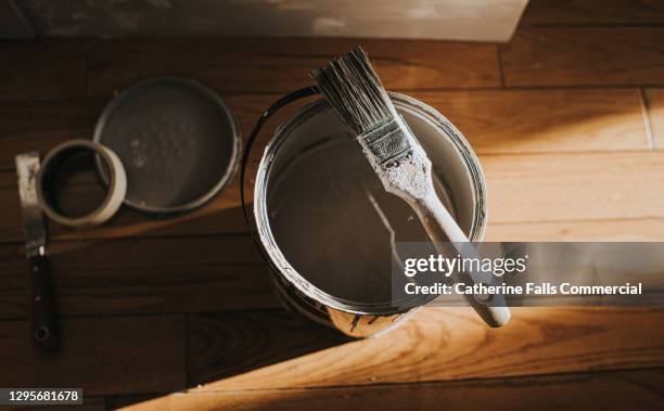 top down image of a paint brush rests on top of a large pot of grey paint - matte finish stock pictures, royalty-free photos & images