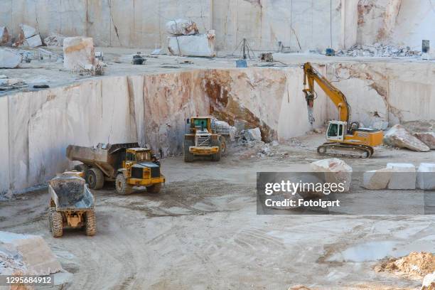 construction vehicles working in marble quarry with oversized marble blocks - mineral stock pictures, royalty-free photos & images