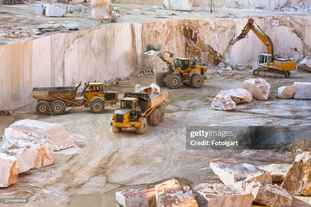 Baufahrzeuge im Marmorbruch mit überdimensionalen Marmorblöcken