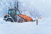 Front loader removes tons of snow from a country road in heavy snowfall