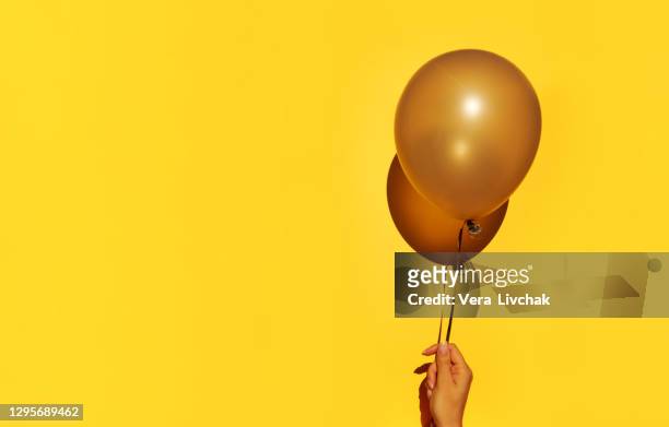 woman holding yellow balloon on color background - work anniversary stock pictures, royalty-free photos & images
