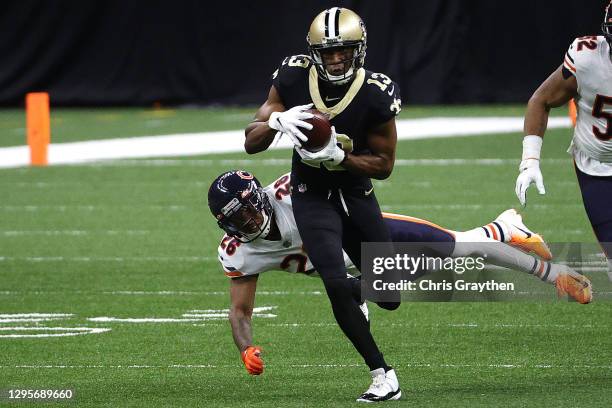 Michael Thomas of the New Orleans Saints runs through a tackle by Deon Bush of the Chicago Bears during the first quarter in the NFC Wild Card...