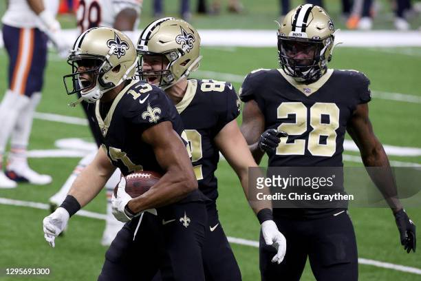 Michael Thomas, Adam Trautman, and Latavius Murray of the New Orleans Saints celebrate following Thomas' 11-yard touchdown during the first quarter...