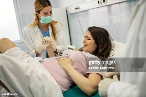 in het ziekenhuis verpleegkundige bevalling ondersteuning, verloskundigen assisteren. moderne bezorgafdeling met professionele verloskundigen - giving birth stockfoto's en -beelden