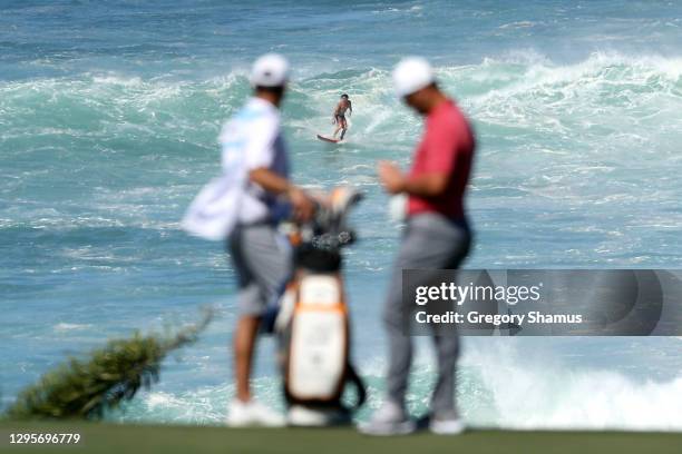 Surfer is seen as Jon Rahm of Spain stands on the 11th green during the final round of the Sentry Tournament Of Champions at the Kapalua Plantation...