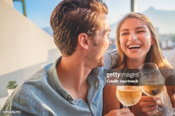 couple on a date at as restaurant. they are drinking white wine and toasting. - couple dinner imagens e fotografias de stock