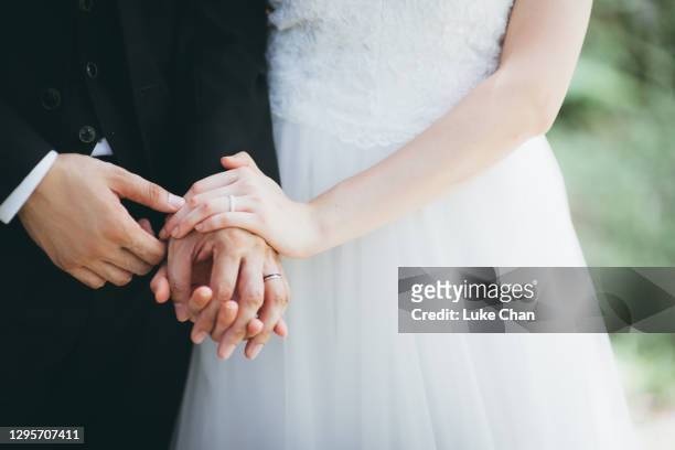 close-up van paar holdinghanden - bruidspaar stockfoto's en -beelden