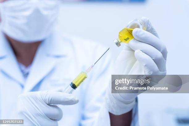 close up of doctor, nurse, scientist, researcher hand in gloves holding flu, measles, covid-19 vaccine disease preparing for human clinical trials vaccination shot, medicine and drug concept. - measles hand stock pictures, royalty-free photos & images