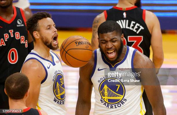 Stephen Curry and Eric Paschall of the Golden State Warriors react after Paschall made a shot and was fouled during their game against the Toronto...